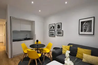 a living room with a couch and a table and chairs at 2 pièces - Croisette in Cannes