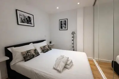 a bedroom with a bed with white sheets and pillows at 2 pièces - Croisette in Cannes