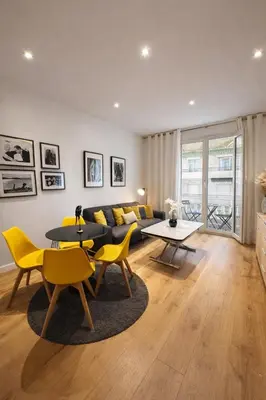 a living room with a couch and a table and chairs at 2 pièces - Croisette in Cannes