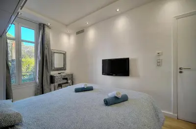 a bedroom with a bed with two blue pillows on it at Clod - 2 bedrooms - Parking - Wifi Air conditioning in Cannes