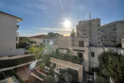 an apartment building with the sun in the sky at Clod - 2 bedrooms - Parking - Wifi Air conditioning in Cannes