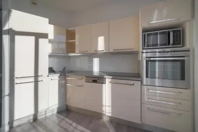 a kitchen with white cabinets and stainless steel appliances at Lumineux 2 Chambres-BALCON-Stanislas Chic A2B264 in Cannes