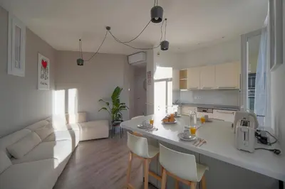 a kitchen and living room with a white counter and chairs at Lumineux 2 Chambres-BALCON-Stanislas Chic A2B264 in Cannes