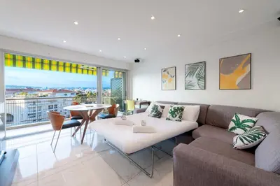 a living room with a couch and a table at 1-Br Apartment with Terrace Near City Centre in Cannes