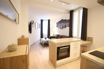 a kitchen with a counter top and a living room at Lovely 1BR flat 15 min walk from La Croisette in Cannes