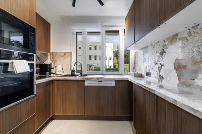 a kitchen with wooden cabinets and a large window at Modern apartment in Cannes 6 people in Cannes