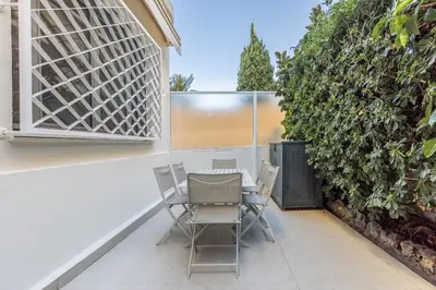 a table and chairs on a patio next to a hedge at Modern 2 Chambres-TERRASSE-POINTE CROISTTE-PALM BEACH A2B267 in Cannes