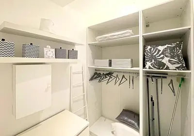 a white walk in closet with white shelves at Viva Riviera Cocoon Apartment Cannes Centre in Cannes