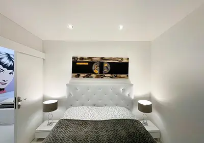 a bedroom with a bed and a clock on the wall at Viva Riviera Cocoon Apartment Cannes Centre in Cannes