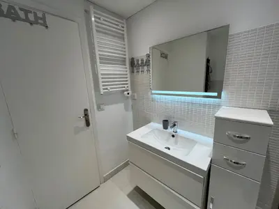a white bathroom with a sink and a mirror at Viva Riviera Cocoon Apartment Cannes Centre in Cannes
