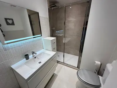 a white bathroom with a sink and a shower at Viva Riviera Cocoon Apartment Cannes Centre in Cannes