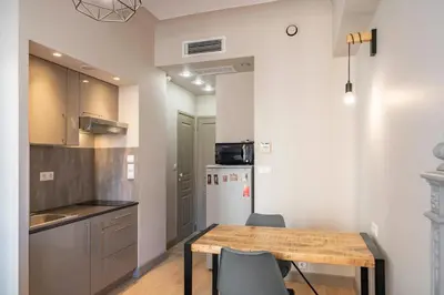 a kitchen with a table and chairs and a refrigerator at COZYSTAY - 1124 - 3-Bedroom Apartment in the Heart of Cannes with Terrace in Cannes