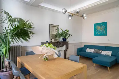 a living room with a table and a blue couch at COZYSTAY - 1124 - 3-Bedroom Apartment in the Heart of Cannes with Terrace in Cannes