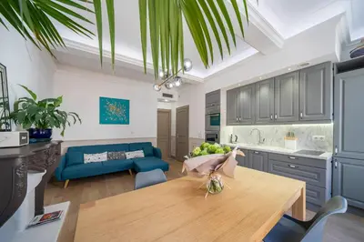 a kitchen and living room with a wooden table at COZYSTAY - 1124 - 3-Bedroom Apartment in the Heart of Cannes with Terrace in Cannes