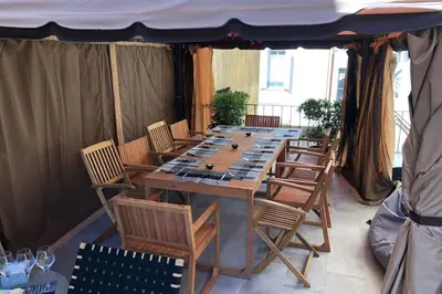 a long wooden table and chairs in a tent at COZYSTAY - 1124 - 3-Bedroom Apartment in the Heart of Cannes with Terrace in Cannes