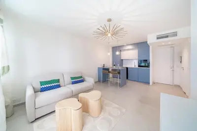 a living room with a couch and a kitchen at Chic appartement 2 pièces in Cannes
