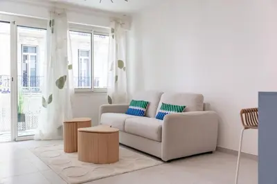 a white living room with a couch and tables at Chic appartement 2 pièces in Cannes