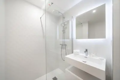 a white bathroom with a sink and a shower at Chic appartement 2 pièces in Cannes