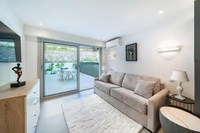 a living room with a couch and a table at Charming bright studio with spacious outdoor area in Cannes