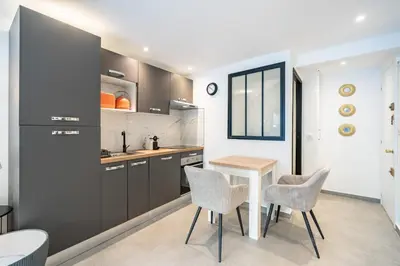 a kitchen with a table and chairs in a room at Charming bright studio with spacious outdoor area in Cannes