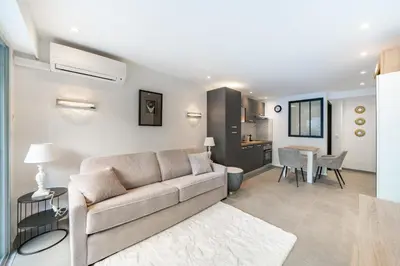 a living room with a couch and a dining room at Charming bright studio with spacious outdoor area in Cannes
