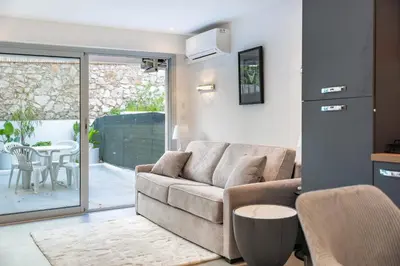 a living room with a couch and a table at Charming bright studio with spacious outdoor area in Cannes