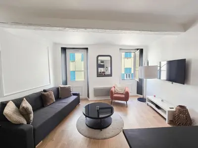 a living room with a couch and a table at 67m2, cannes vieille-ville, 9min à pied du palais in Cannes