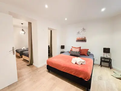 a bedroom with a bed with a orange comforter at 67m2, cannes vieille-ville, 9min à pied du palais in Cannes