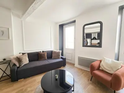 a living room with a couch and a table and a mirror at 67m2, cannes vieille-ville, 9min à pied du palais in Cannes
