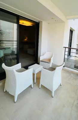 a group of white chairs and a table on a balcony at Residence Carlton Riviera in Cannes