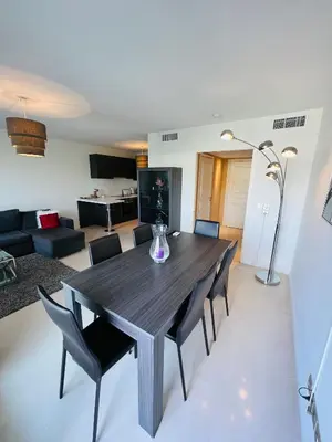 a dining room and living room with a table and chairs at Residence Carlton Riviera in Cannes