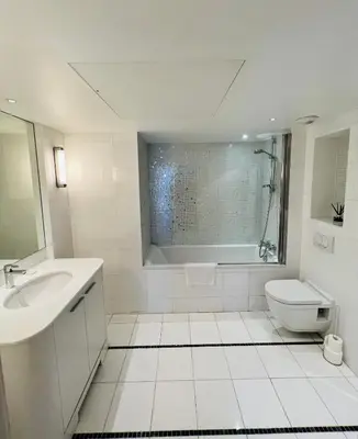 a white bathroom with a sink and a toilet at Residence Carlton Riviera in Cannes