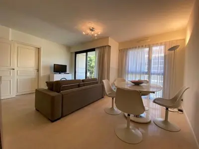a living room with a couch and a table and chairs at Residence Carlton Riviera in Cannes