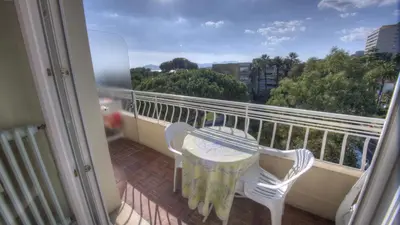 a balcony with a table and two chairs on a balcony at Studio 3 étoiles Vue mer 150m Plages Parking Clim WIFI in Cannes