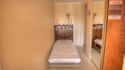 a small room with a bed and a mirror at Studio 3 étoiles Vue mer 150m Plages Parking Clim WIFI in Cannes