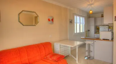 a living room with a couch and a table and a mirror at Studio 3 étoiles Vue mer 150m Plages Parking Clim WIFI in Cannes