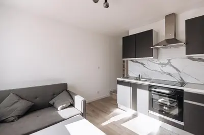 a living room with a couch and a kitchen at Cozy 2-bedroom apartment - Close to Palais, Croisette in Cannes