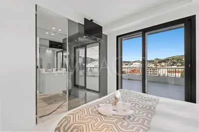 a living room with a couch and a large window at REF 2027 - Cannes Centre - Apartment for Rent in Cannes