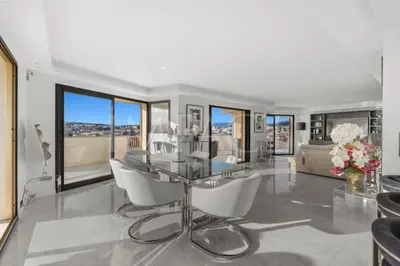 a living room with a glass table and white chairs at REF 2027 - Cannes Centre - Apartment for Rent in Cannes