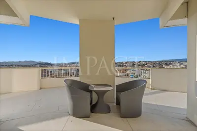 a pair of chairs on a balcony with a view at REF 2027 - Cannes Centre - Apartment for Rent in Cannes