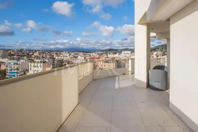 a balcony with a view of a city at REF 2027 - Cannes Centre - Apartment for Rent in Cannes