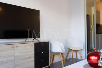 a living room with two white chairs and a flat screen tv at Cannes Croisette - 2035 Studio For rent in Cannes
