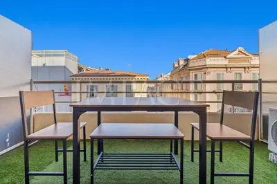 a table and chairs on a balcony with buildings at Cannes Croisette 2034 - Studio for rent in Cannes
