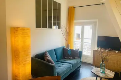 a living room with a blue couch and a window at Bright apartment in Cannes for 5 people in Cannes