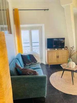 a living room with a blue couch and a tv at Bright apartment in Cannes for 5 people in Cannes