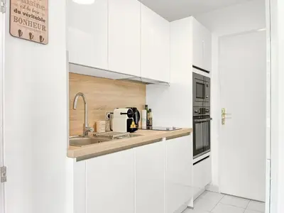 a white kitchen with white cabinets and a sink at Cannes Estello - Comfortable accommodation Terrace Parking in Cannes