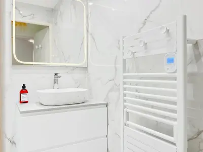 a white bathroom with a sink and a mirror at Cannes Estello - Comfortable accommodation Terrace Parking in Cannes