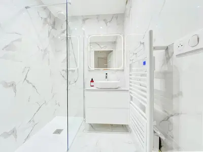 a white bathroom with a shower and a sink at Cannes Estello - Comfortable accommodation Terrace Parking in Cannes