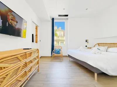 a bedroom with a bed and a large window at Nova - near sea and beaches in Cannes