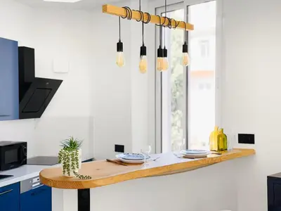 a kitchen with a wooden table with plates on it at Nova - near sea and beaches in Cannes
